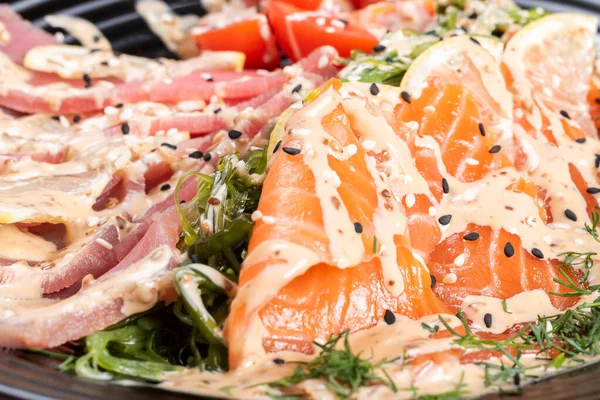 Lax och tonfisk sashimi i en sallad med örter. — Stockfoto