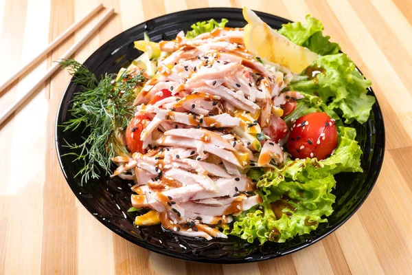 Ensalada de pollo japonesa en un plato negro . — Foto de Stock