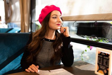 Kız bir kafede bir masada oturuyor..