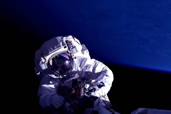 Astronauta en la estación espacial se dedica a reparaciones. Elementos de esta imagen fueron proporcionados por la NASA . —  Fotos de Stock