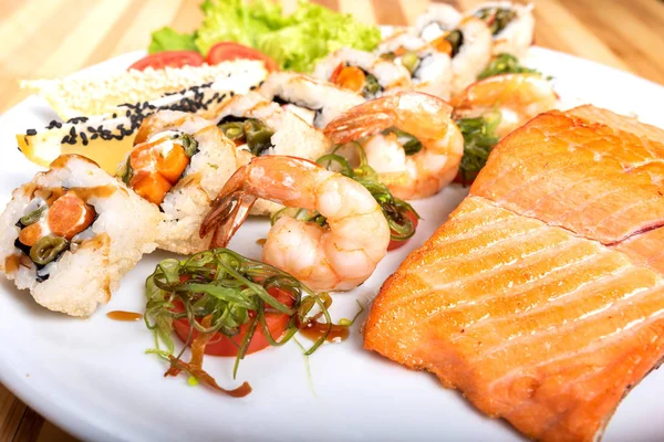 Sushi surtido, camarones y un trozo de salmón a la parrilla . — Foto de Stock