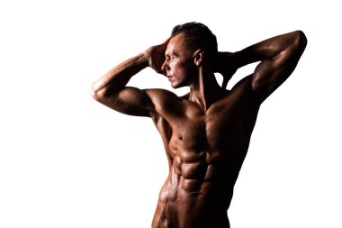 Çıplak gövdeli, bronz tenli bir adam ellerini başının arkasında tutuyor. Beyaz bir arkaplanda izole edilmiş.