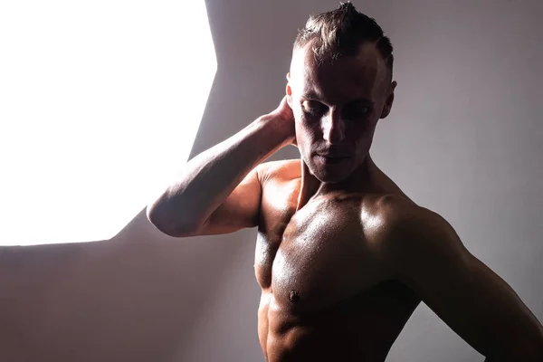 Αθλητικός, μαυρισμένος άντρας με γυμνό κορμό να ποζάρει στο στούντιο.. — Φωτογραφία Αρχείου