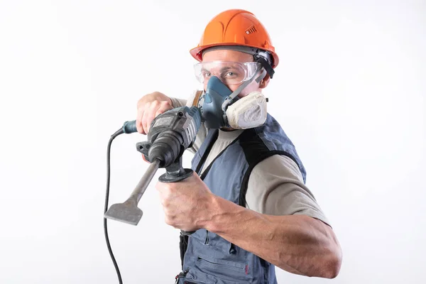Constructor con un perforador, en un casco y un respirador. Objetivo: . — Foto de Stock