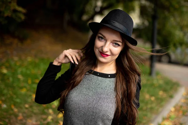 Menina com cabelo longo fluindo em um chapéu preto . — Fotografia de Stock