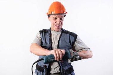 Yüzünde komik bir ifadeyle, miğferli, açı öğütücü takan bir miğfer..