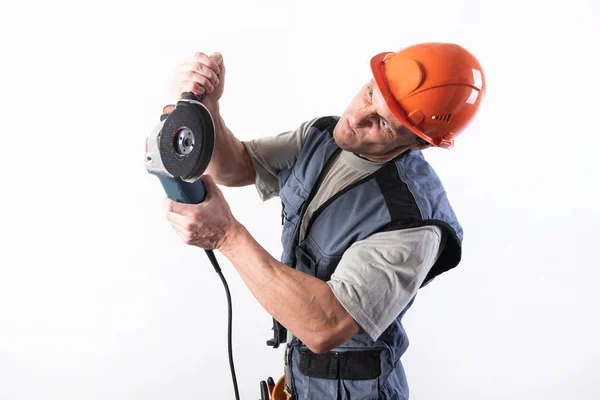 Constructor con amoladora angular, en un casco, con una expresión divertida en su rostro . — Foto de Stock