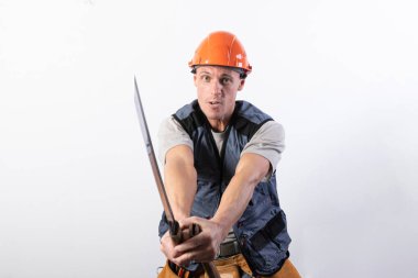 Müteahhit bir katana ile kavga ettiğini gösteriyor. Kask takan ve iş kıyafeti giyen bir tamirci..