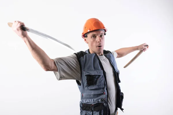 O construtor faz um golpe de corte de baixo com uma katana. Reparador vestindo um capacete e roupas de trabalho . — Fotografia de Stock