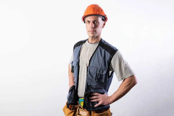 El constructor puso sus manos en sus caderas. En ropa de trabajo y sombrero duro . — Foto de Stock