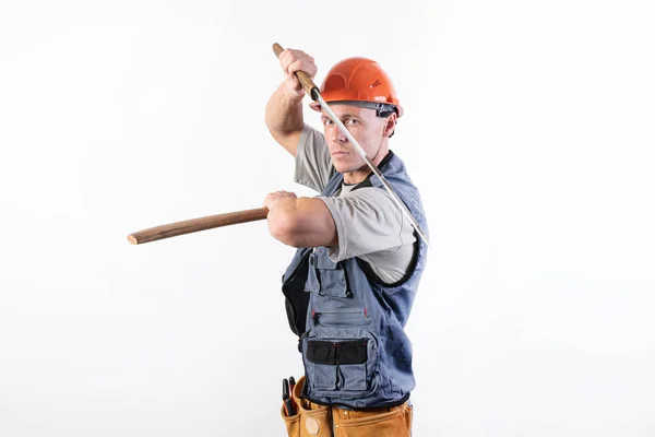 El constructor muestra una pelea con una katana. Reparador con casco y ropa de trabajo . —  Fotos de Stock