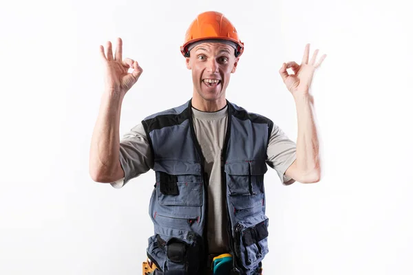 El constructor muestra el signo bien. En ropa de trabajo y un casco . — Foto de Stock