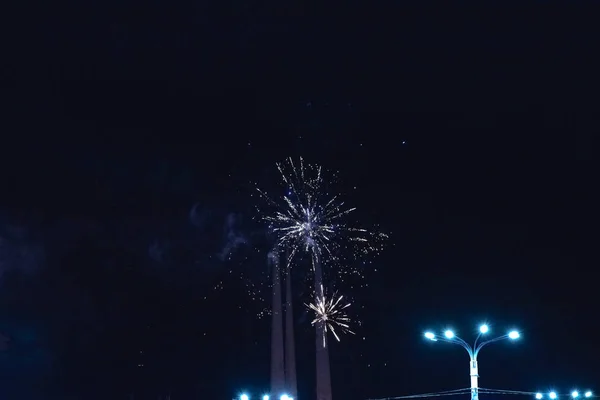 Een eenvoudig vuurwerk met brandende lantaarns op de voorgrond. — Stockfoto