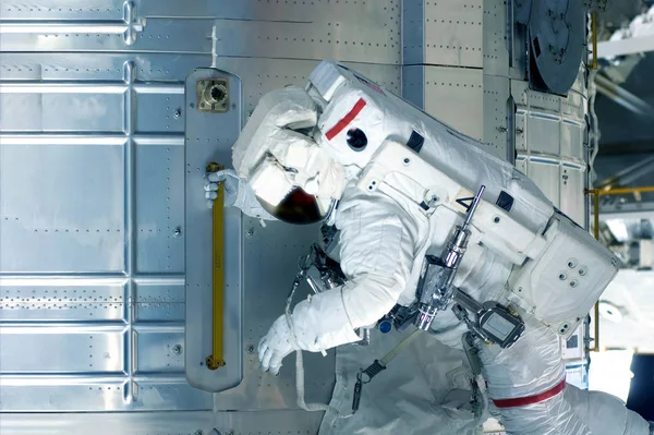 Astronauta en traje espacial, vista lateral, en una estación espacial. Elementos de esta imagen fueron proporcionados por la NASA . —  Fotos de Stock