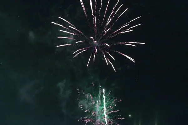 Fogos de artifício verdes brilhantes contra o céu escuro . — Fotografia de Stock