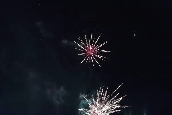 Fogo de artifício vermelho simples contra o céu escuro . — Fotografia de Stock