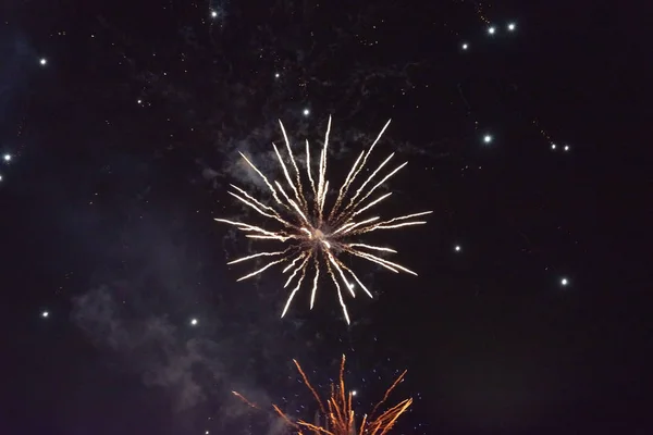Een flits van gewoon wit en oranje vuurwerk. Aan de nachtelijke hemel — Stockfoto