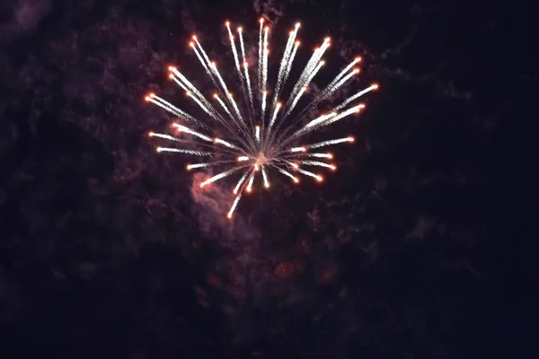 Mooi goedkoop rood vuurwerk tegen de donkere lucht. Met rook. — Stockfoto