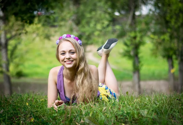 Güzel sarışın kız çimenlerde uzanıyor ve gülüyor.. — Stok fotoğraf