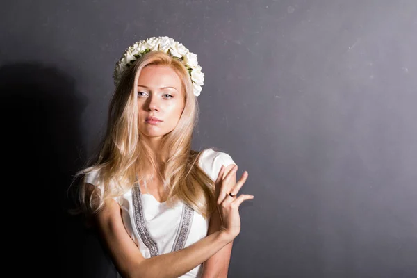 Hermosa chica rubia en el estudio. En un vestido blanco, sobre un fondo oscuro . — Foto de Stock