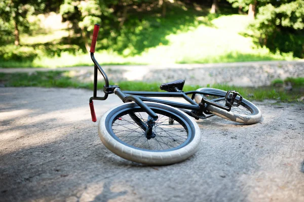 Bmx rower leżący na chodniku w parku. — Zdjęcie stockowe