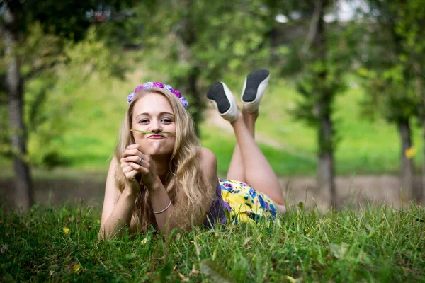 Mädchen im Gras mit einem lustigen Gesichtsausdruck. — Stockfoto