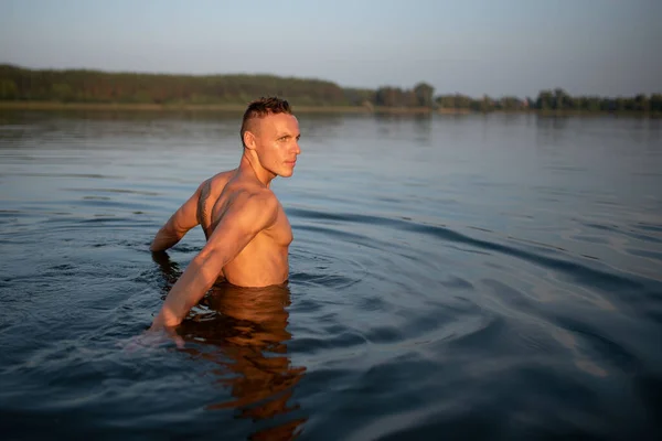 Uomo atletico sul lago. Profondità della vita in acqua. Al tramonto . — Foto Stock