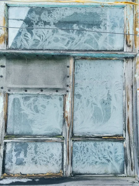 Frostmuster am Fenster eines alten Hauses, ähnlich wie Äste von Bäumen. — Stockfoto