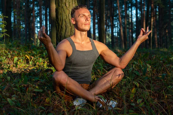 Um homem faz ioga ao pôr-do-sol. Ao ar livre . — Fotografia de Stock