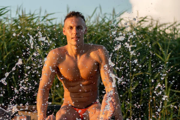 Um homem espirra água em um lago . — Fotografia de Stock