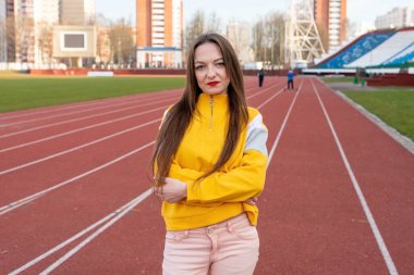 Sıradan kıyafetlerle, stadyumun koşu bandında. Herhangi bir amaç için
