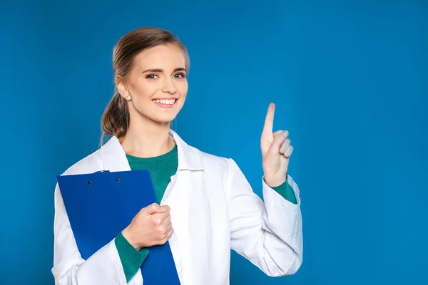 兆しが青の背景にタブレットで若い女子学生医師 — ストック写真