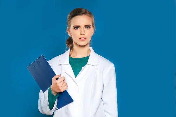 兆しが青の背景にタブレットで若い女子学生医師 — ストック写真