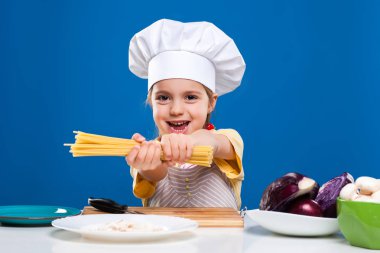 Küçük kız mavi zemin üzerine gıda hazırlama