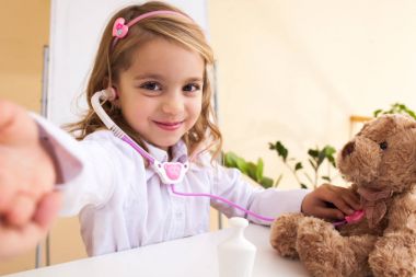 Küçük kız bir oyuncak ayı ve selfie yapma davranır