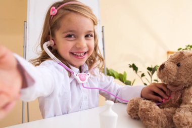 Küçük kız bir oyuncak ayı ve selfie yapma davranır