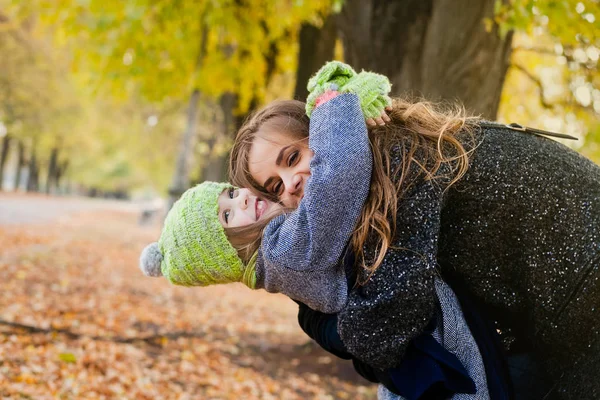 Мать гуляет с дочерью на открытом воздухе осенью — стоковое фото