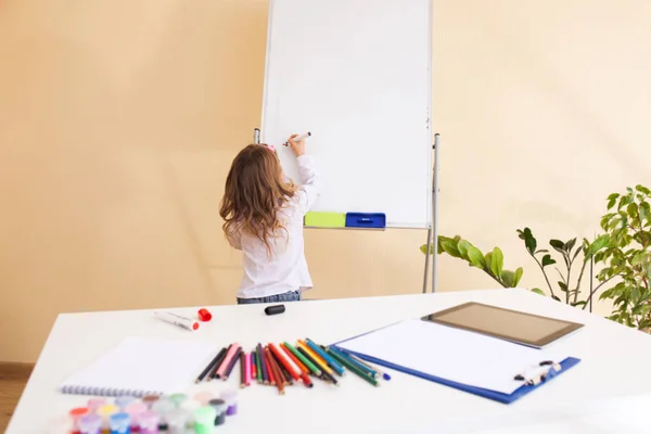 Little girl draws on the white board — Stock Photo, Image