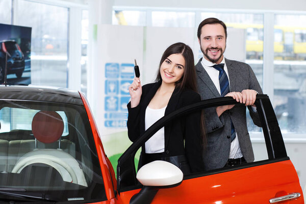 пара выбирает машину в выставочном зале
