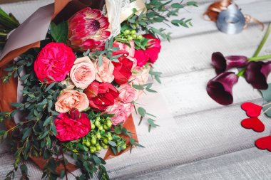 Pembe ve kırmızı gül buketi spase metin için ahşap bir masaya yatıyor