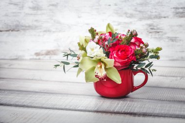 Buket çiçek ve lilyum ahşap tablo alanı için metin üzerinde küçük kırmızı vazo