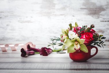 Buket çiçek ve lilyum ahşap tablo alanı için metin üzerinde küçük kırmızı vazo