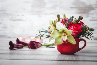 Buket çiçek ve lilyum ahşap tablo alanı için metin üzerinde küçük kırmızı vazo