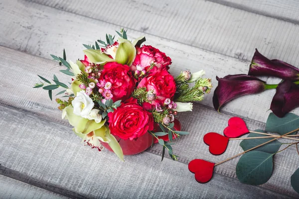 Boeket van rode rozen in de rode vaas, harten, callas op tafel, ruimte voor tekst — Stockfoto