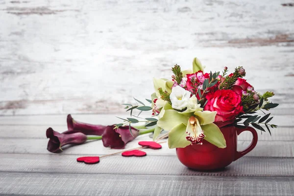 Kleine rode vaas met een boeket van bloemen en lelies op houten tafel ruimte voor tekst — Stockfoto