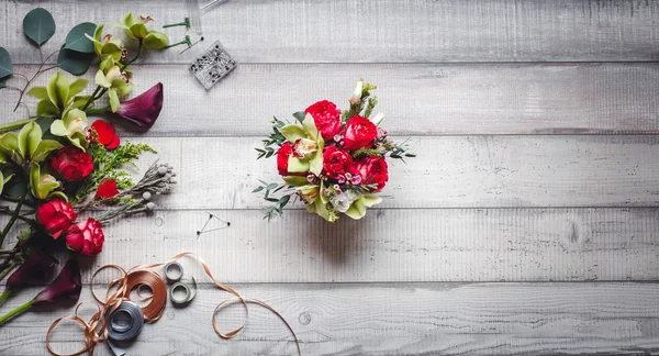 Boeket van rode rozen, hartjes, callas, anjers en linten op tafel — Stockfoto