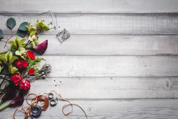 Bloemen, callas, anjers en linten aan de kant op witte tabel — Stockfoto