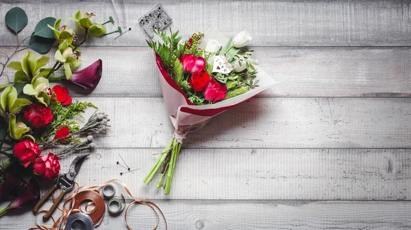 Boeket van rode en witte rozen, hartjes, callas, anjers en linten op tafel — Stockfoto