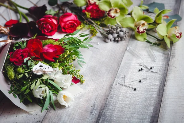Boeket van witte en rode tulpen ligt op een houten tafel — Stockfoto