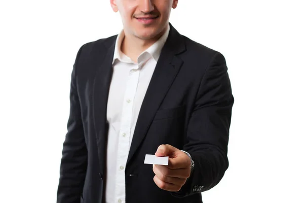 Junger Mann im Anzug auf weißem Hintergrund gibt Kreditkarte — Stockfoto